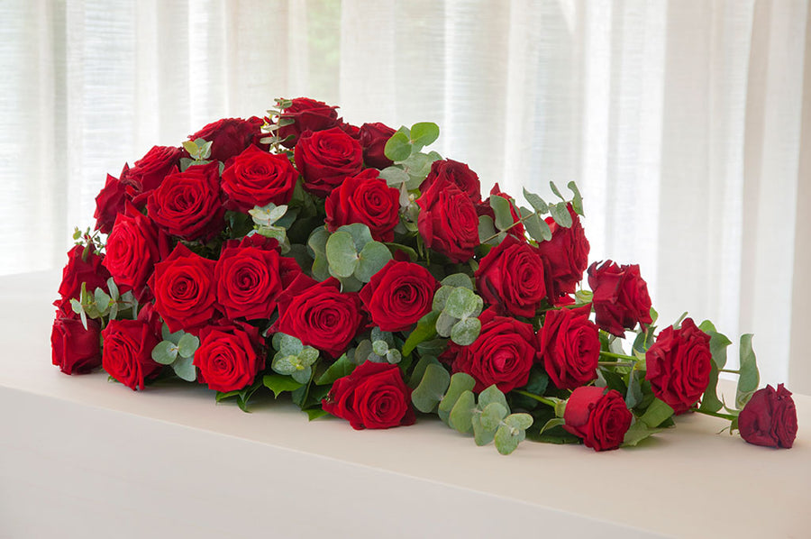 Druppelvormig rouwarrangement van rozen. Klassiek rouwstuk voor een begrafenis of crematie.