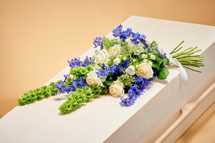 Rouwboeket met blauwe en witte bloemen. Liefdevol boeket voor een begrafenis of crematie.