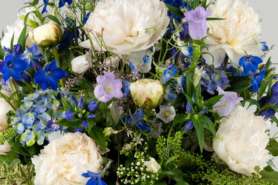 Geliefde kleurencombinatie wit en blauw. Bloemenmand Kalmte bevat een diversiteit aan bloemen.