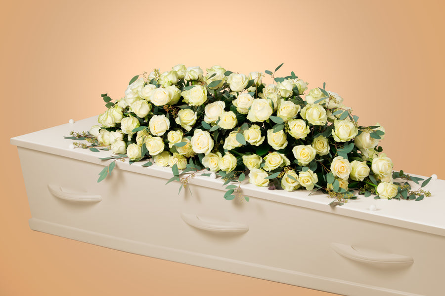 Kistbedekking met witte Rozen. Luxe bloemstuk voor op een kist.