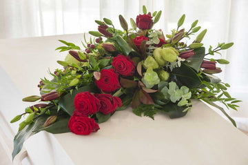 Een klassiek rouwstuk met rozen en lelies van UitvaartBloemist. 