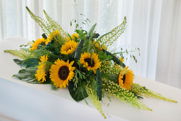 Een prachtig rouwstuk van zonnebloemen. 